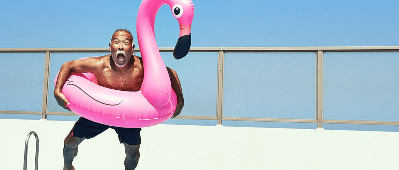 um homem a saltar para uma piscina