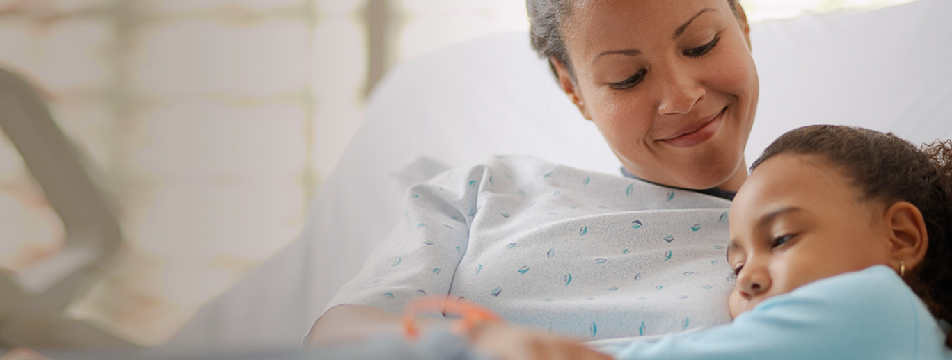 Nainen syleilee lasta